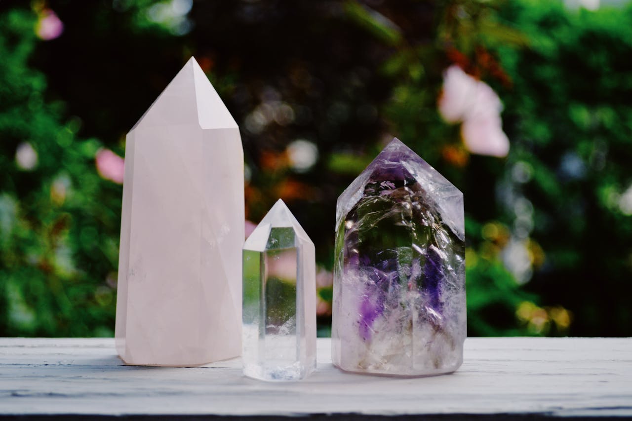 Services A beautiful arrangement of crystals including amethyst and quartz displayed outdoors.