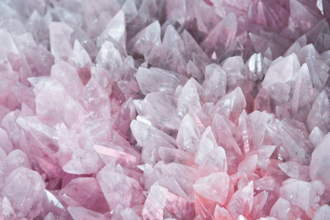About A detailed close-up of rose quartz crystals showcasing their pink hues and translucent nature.