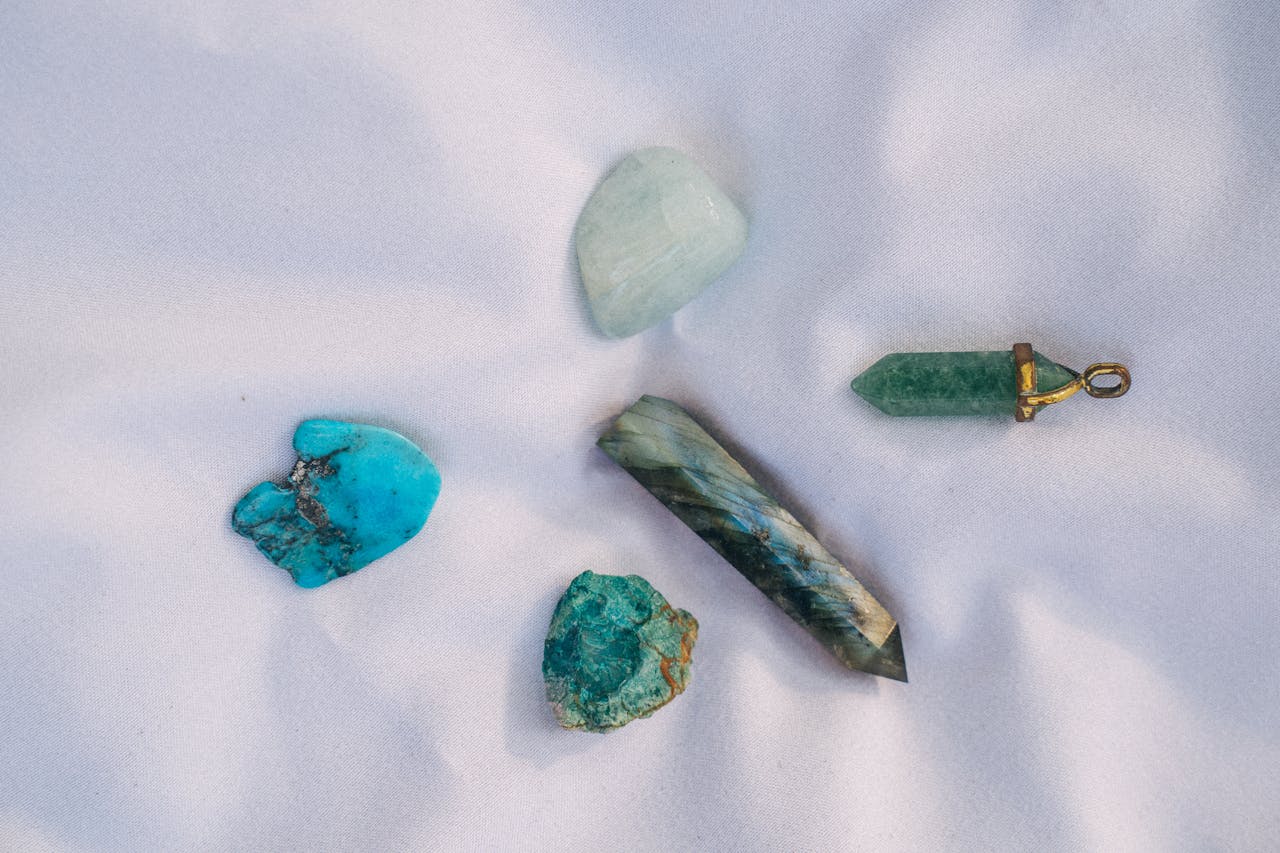 An assortment of healing crystals displayed on white fabric, representing alternative medicine and spiritual themes.