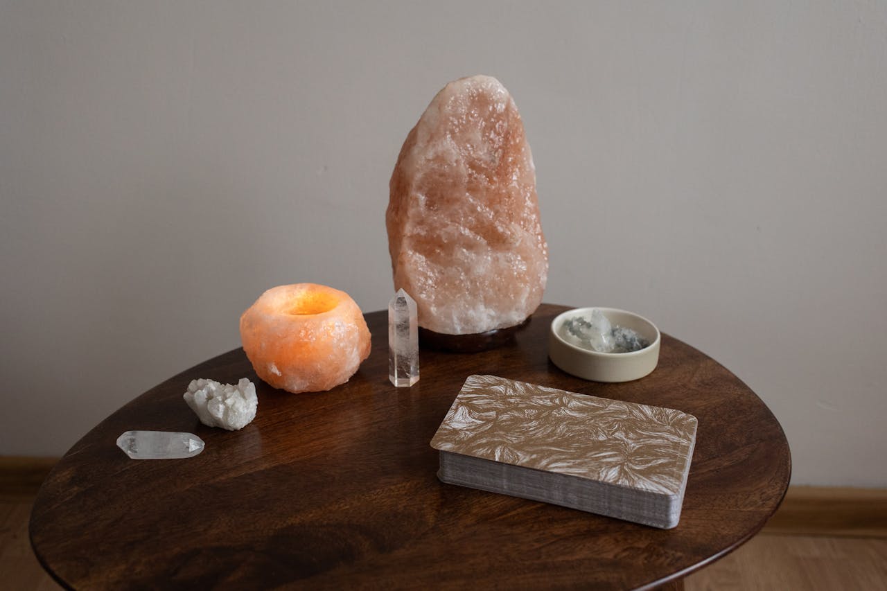 A collection of crystals and tarot cards on a wooden table for spiritual practice.